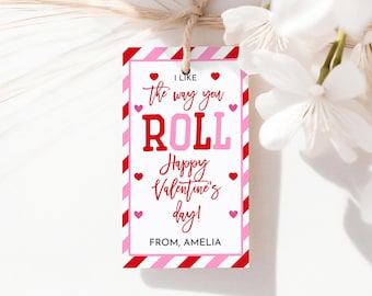 May include: A Valentine's Day gift tag with a red and pink striped border. The tag reads "I like the way you ROLL. Happy Valentine's day!" in red and pink lettering. The tag is tied with twine and has the name "AMELIA" at the bottom.