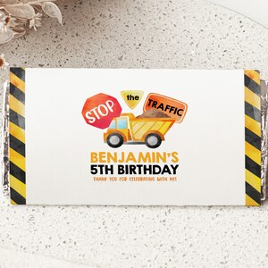 May include: A yellow construction truck with a load of dirt, a red stop sign, and a yellow sign that says "the traffic". The text below the truck says "Benjamin's 5th Birthday" and "Thank you for celebrating with me".