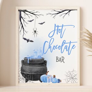 May include: A printable sign for a Halloween hot chocolate bar. The sign features a black cauldron with blue steam, a blue pumpkin, and a bottle of potion. The text on the sign reads "Hot Chocolate Bar" in blue cursive writing.
