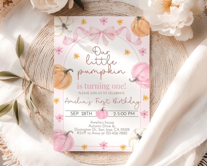 May include: A pink and white birthday invitation with watercolor pumpkins, flowers, and a bow. The text reads "Our little pumpkin is turning one!" and includes the date, time, and location for Amelia's first birthday.