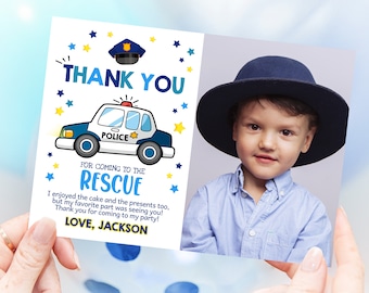 May include: A blue and white police car with yellow stars and a police officer's hat on top. The car says "POLICE" on the side. The text "THANK YOU FOR COMING TO THE RESCUE" is written in blue and yellow. The text "I enjoyed the cake and the presents too, but my favourite part was seeing you! Thank you for coming to my party! LOVE, JACKSON" is written in black. A photo of a young boy wearing a blue hat is in the background.