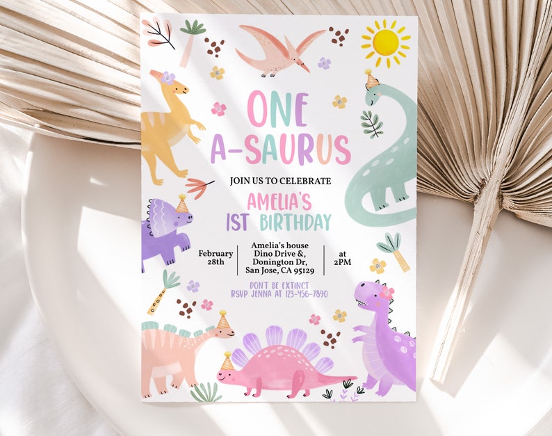 May include: A colorful invitation for a first birthday party with a dinosaur theme. The invitation features a variety of dinosaurs in pink, purple, blue, and yellow, with the text "ONE A-SAURUS" in pink and purple letters. The invitation also includes the date, time, and location of the party.