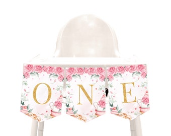 May include: A pink and gold high chair banner with the word "ONE" in gold glitter letters. The banner features a floral design with pink roses and green leaves.