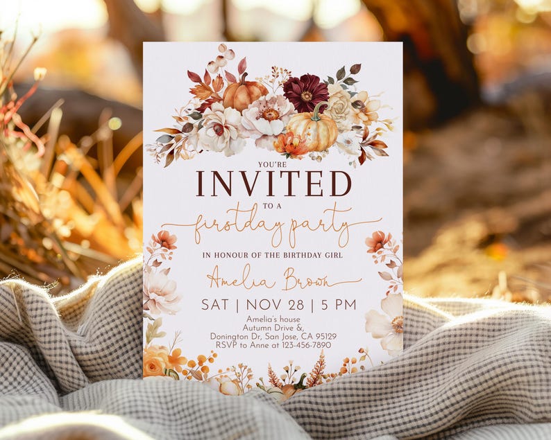 May include: A rectangular invitation card with the text "YOU'RE INVITED to a firstday party" in brown and white. The card features floral and pumpkin illustrations in shades of orange, white, and burgundy. The name "Amelia Brown" is also included.