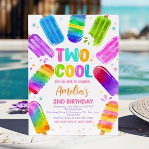 May include: A colorful invitation for a 2nd birthday party with a popsicle theme. The invitation features the text "TWO COOL" in a rainbow font and a variety of colorful popsicles. The text "Amelia's 2nd Birthday" is also included, along with the date, time, and location of the party.