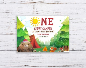 May include: A printable first birthday invitation featuring a cartoon bear wearing a hat, a red tent, a campfire, and a squirrel. The text reads "One Happy Camper Jackson's First Birthday! Your Text Here your text here".
