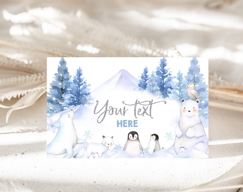May include: A watercolor illustration of a winter scene with a polar bear, a seal, a fox, and two penguins. The background features a snowy mountain, blue pine trees, and snowflakes. The text "Your text here" is written in silver glitter.
