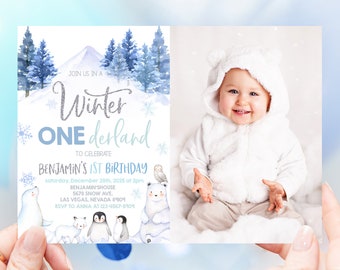May include: A blue and white winter wonderland themed first birthday invitation with a photo of a baby in a white hooded outfit. The invitation says "Join us in a Winter Wonderland to celebrate Benjamin's 1st Birthday" with the date and time of the party, the address, and RSVP information.