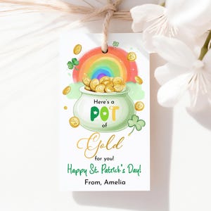 以下が含まれることがあります： 聖パトリックの日のテーマの白いギフトタグ。金の入ったポット、虹、そして「Here's a POT of Gold for you! Happy St. Patrick's Day! From, Amelia.」というテキストが特徴です。