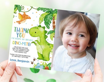 May include: A green dinosaur with a cute face and a blue and orange pterodactyl flying above it. The text "THANK YOU FOR MAKING MY BIRTHDAY DINO-MITE!" is written in blue, orange, and yellow. The text "I ENJOYED THE CAKE AND THE PRESENTS TOO, BUT MY FAVORITE PART WAS SEEING YOU! THANK YOU FOR CELEBRATING MY BIRTHDAY WITH ME! Love, Benjamin" is written in black. A photo of a young boy is in the background.
