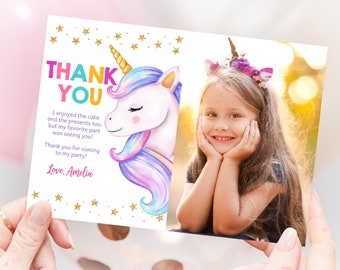 May include: A thank you card with a watercolor illustration of a unicorn with a rainbow mane and a gold horn. The card has a gold glitter border and the text "THANK YOU" in colorful letters. The card also includes the text "I enjoyed the cake and the presents too, but my favorite part was seeing you! Thank you for coming to my party! Love, Amelia".
