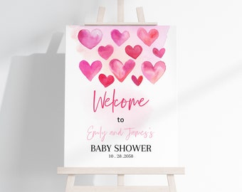 May include: A pink and white welcome sign with watercolor hearts and the text "Welcome to Emily and James's Baby Shower 10.28.2058"