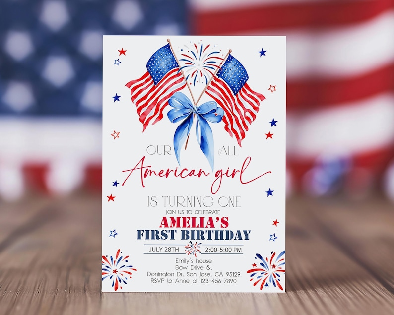 May include: A white invitation card with a patriotic theme. It features illustrations of American flags, fireworks, and a blue bow. The text reads "Our American girl is turning one" and includes details for Amelia's first birthday, July 28th.