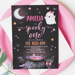 May include: A black and white Halloween party invitation with a pink and white ghost, a black cat, and a cauldron. The text reads "Amelia is a spooky one, Join us to celebrate her 1st Boo-Day, Saturday, September 28th at 2:00 PM, Emily's House, Boo Drive & Donington Dr, San Jose, CA 95129, RSVP to Anne at 123-456-7890".