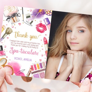 Puede incluir: Tarjeta de agradecimiento rosa y morada con una foto de una niña. La tarjeta tiene un diseño de acuarela con artículos de maquillaje y el texto "gracias" y "Spa-taculars".