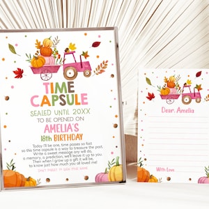 May include: A pink and white time capsule sign with a tractor carrying pumpkins and fall leaves. The sign says "Time Capsule Sealed Until 20XX To Be Opened On Amelia's 18th Birthday". A smaller card says "Dear Amelia" and has lines for writing a message.