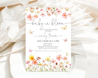 May include: A baby shower invitation with a floral design. The invitation reads "baby in bloom" and includes the date, time, and location of the shower. It also includes the name "emily brook" and the text "Registered at Amazon and Target.com".