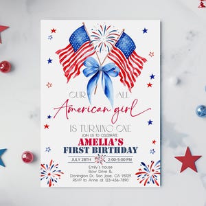 May include: An invitation card featuring American flags, fireworks, and a blue bow. The text reads "Our American girl is turning one" and announces Amelia's first birthday on July 28th. Decorative stars and details in red, white, and blue.