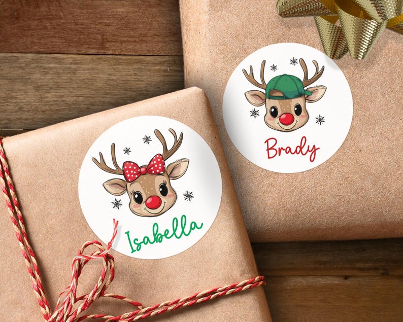 May include: Two round Christmas gift tags with reindeer illustrations. One tag features a red-nosed reindeer wearing a green hat with the name "Brady" printed below. The other tag features a reindeer with a red bow and the name "Isabella" printed below.