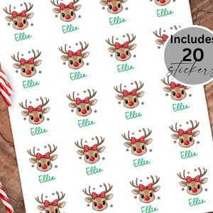 May include: Twenty red and white reindeer stickers with the name Ellie printed on each sticker. The stickers are on a white sheet of paper.