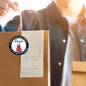 May include: A brown paper shopping bag with a round sticker that says "Thank you for your support! Bryce. You can rate me in the app!" The sticker has a red bear design.