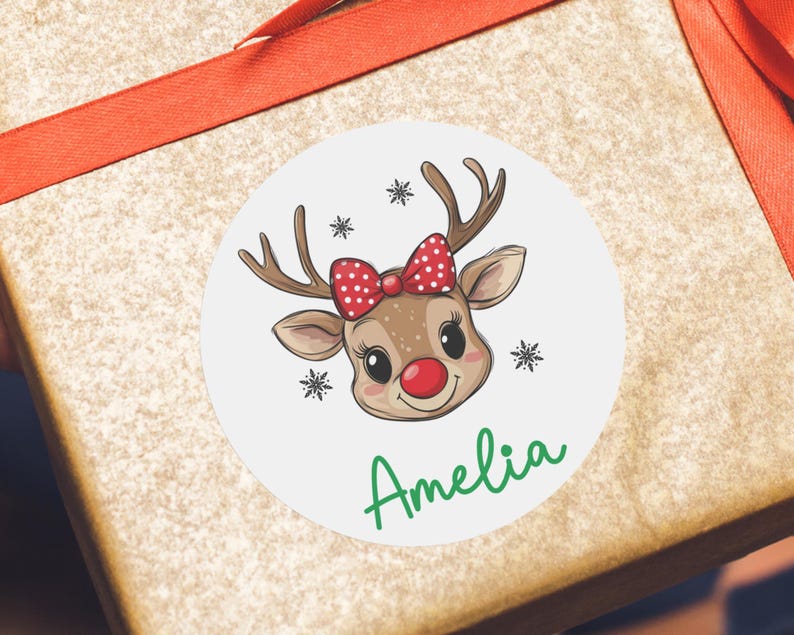 May include: A round sticker with a cartoon reindeer with red and white polka dot bow. The reindeer has a red nose and the sticker says "Amelia" in green text.