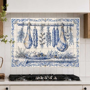 Peut inclure: Une fresque murale en carrelage décoratif présentant une illustration bleue et blanche de viandes séchées, d'ail et d'herbes suspendus à une tige au-dessus d'un bol d'olives et d'ail. L'ensemble est encadré par une bordure ornementale bleue et blanche.