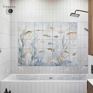 Op de afbeelding: Een rechthoekige muurschildering bestaande uit vierentwintig vierkante keramische tegels met een aquarelillustratie van een onderwaterscène met diverse vissen, zeewier en koraal in blauwe, grijze en oranje tinten, inclusief het Tempera Ceramic logo.