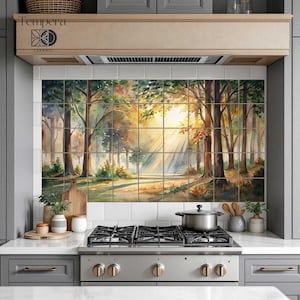 Könnte beinhalten: Eine Küchenrückwand mit einem Aquarellgemälde einer Waldszene mit Sonnenlicht, das durch die Bäume scheint. Das Kunstwerk besteht aus mehreren quadratischen Fliesen. Die Szene umfasst Bäume, einen Pfad und eine warme Farbpalette. Der Markenname "Tempera Ceramic" ist sichtbar.