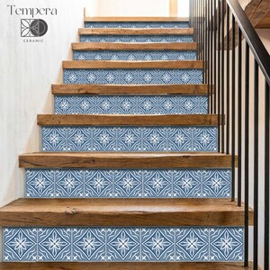 Può includere: Scala in legno con alzatine in piastrelle di ceramica a motivi blu e bianchi. Le piastrelle presentano un disegno floreale. La scala ha un corrimano in legno e una parete bianca. Il marchio "Tempera Ceramic" è visibile.
