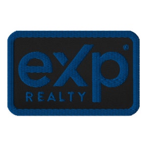 Può includere: Toppa ricamata blu e nera con il testo "exp" in un font stilizzato e il testo "REALTY" sotto.