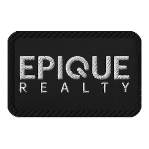 May include: A black rectangular patch with the embroidered text "EPIQUE REALTY" in white. The patch has a stitched border, and the letters are in a bold, sans-serif font, creating a professional appearance.