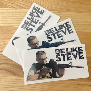 May include: Three white stickers with the text "Be Like Steve" in black, each featuring a different photo of a man holding a rifle. The man in each photo is wearing a black shirt and a black hat.