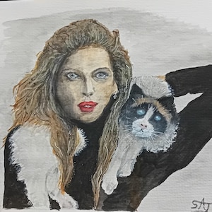 Puede incluir: Una pintura de acuarela de una mujer con cabello largo y castaño que lleva un suéter negro de cuello alto y sostiene un gato blanco y gris. El gato tiene ojos azules y mira al espectador. La pintura tiene un fondo gris y está firmada "SAT" en la esquina inferior derecha.