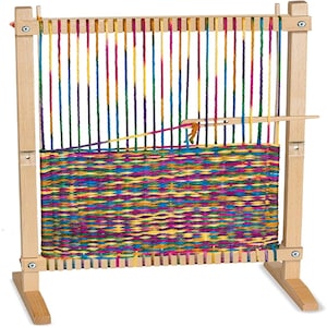 May include: A wooden loom with colorful yarn woven into a tapestry. The loom has a wooden frame and a wooden shuttle. The yarn is a variety of colors, including red, orange, yellow, green, blue, purple, and pink.