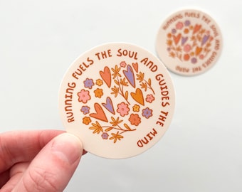 May include: Two round stickers with the text "RUNNING FUELS THE SOUL AND GUIDES THE MIND". The stickers feature a floral design with hearts, flowers, and leaves in orange, purple, and pink on a cream background.