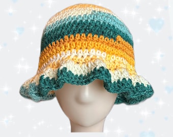 May include: A crocheted bucket hat with a green, yellow, and white striped pattern. The hat has a ruffled brim.