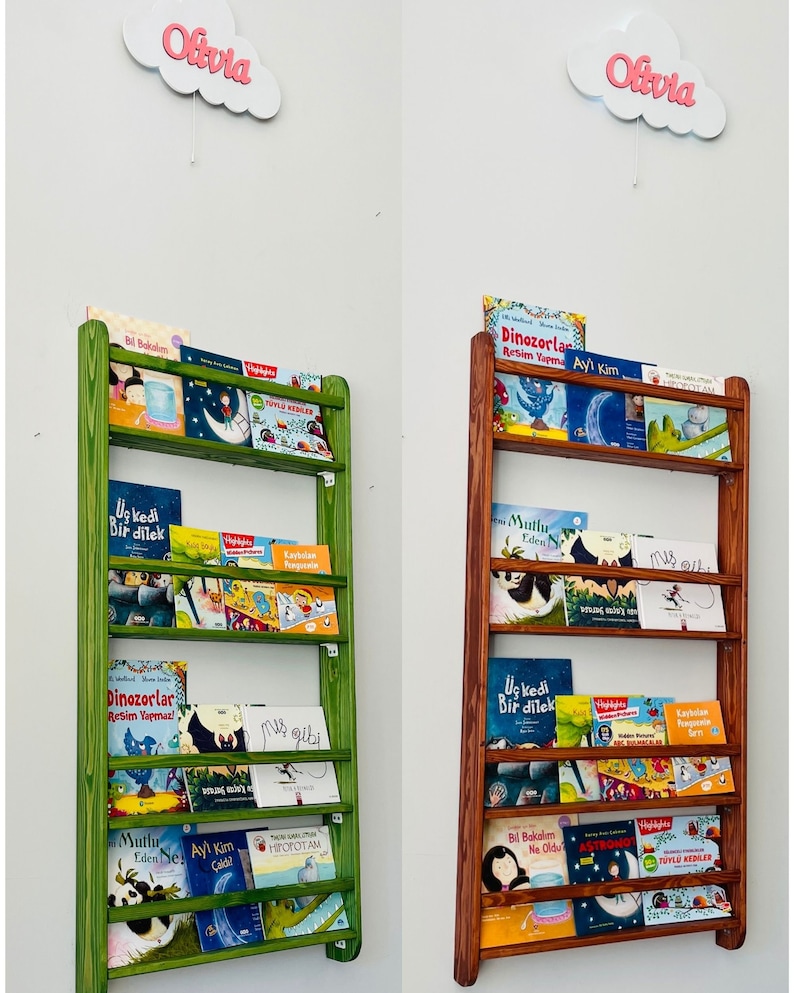 May include: Two wooden bookshelves with different colored stains, one green and one brown. Both shelves are filled with children's books with colorful covers. The shelves are labeled with the name "Olivia" at the top.