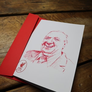 Può includere: Un biglietto rosso e bianco con un'illustrazione rossa di un uomo sorridente. Il biglietto ha un logo rosso del Liverpool Football Club nell'angolo in basso a sinistra.