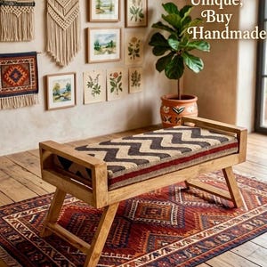May include: A wooden bench with a patterned cushion and a red and blue patterned rug. The bench has a light brown wooden frame and a cushion with a zigzag pattern in brown, beige, and red. The rug has a geometric design. The text "Shop E Unique, Buy Handmade" is visible.