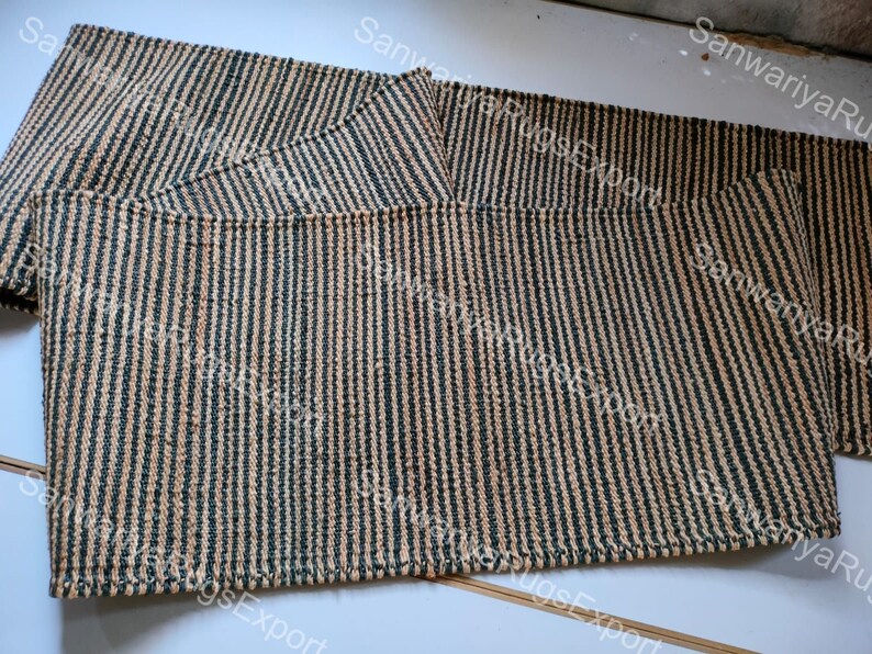 May include: A set of three woven striped rugs in beige and dark green. The rugs are made of natural fibres and have a textured surface.