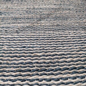 May include: A black and natural jute rug with a woven striped pattern. The rug is made of natural fibres and has a rustic look.