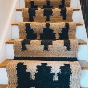 May include: A set of black and beige stair treads with a geometric pattern. The treads are made of a woven material and have a natural, rustic look.
