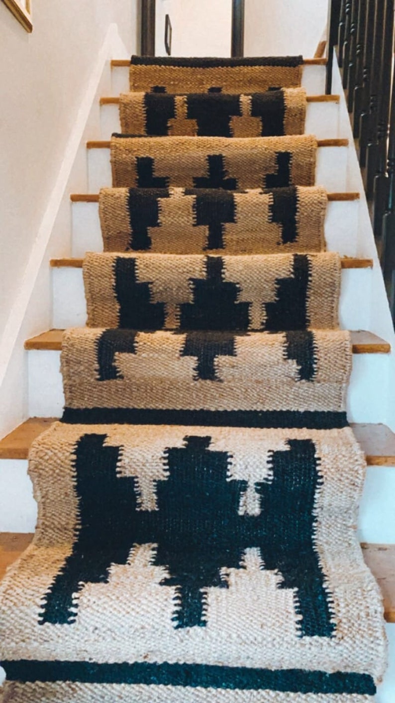 May include: A set of black and beige stair treads with a geometric pattern. The treads are made of a woven material and have a natural, rustic look.
