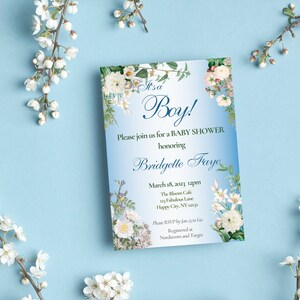 May include: A blue and white baby shower invitation with floral borders. The text reads "It's a Boy!" and includes the name "Bridgette Faye" and the date "March 18, 2023 12pm".