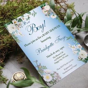 May include: A blue and white baby shower invitation featuring floral illustrations. The invitation reads "It's a Boy!" and includes the text "Please join us for a baby shower honouring Bridgette Fraye". The date, time, location, and RSVP information are also included.