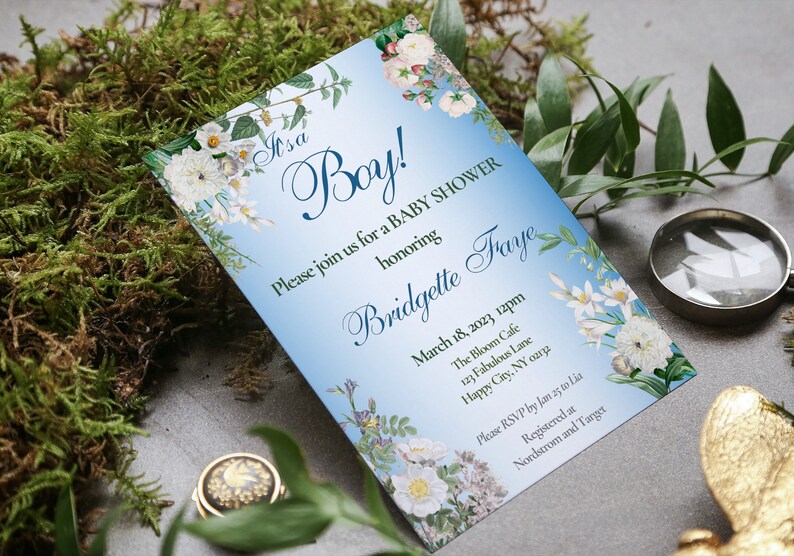 May include: A blue and white baby shower invitation featuring floral illustrations. The invitation reads "It's a Boy!" and includes the text "Please join us for a baby shower honouring Bridgette Fraye". The date, time, location, and RSVP information are also included.