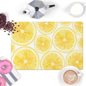 May include: A white rectangular kitchen mat with a lemon pattern. The lemons are yellow with a watercolor effect and are arranged in a repeating pattern.