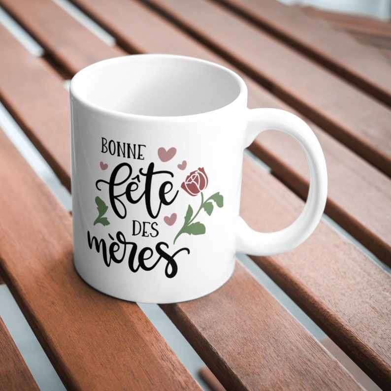 May include: White ceramic mug with a black and white design that says "Bonne fete des meres" with a pink rose and hearts.