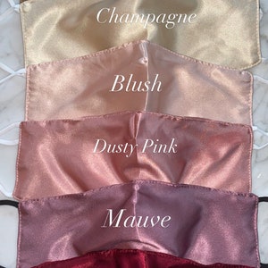 May include: Six satin face masks in different shades of pink and brown. The masks are labeled with the colors: Copper, Champagne, Blush, Dusty Pink, Mauve, and Rouge.